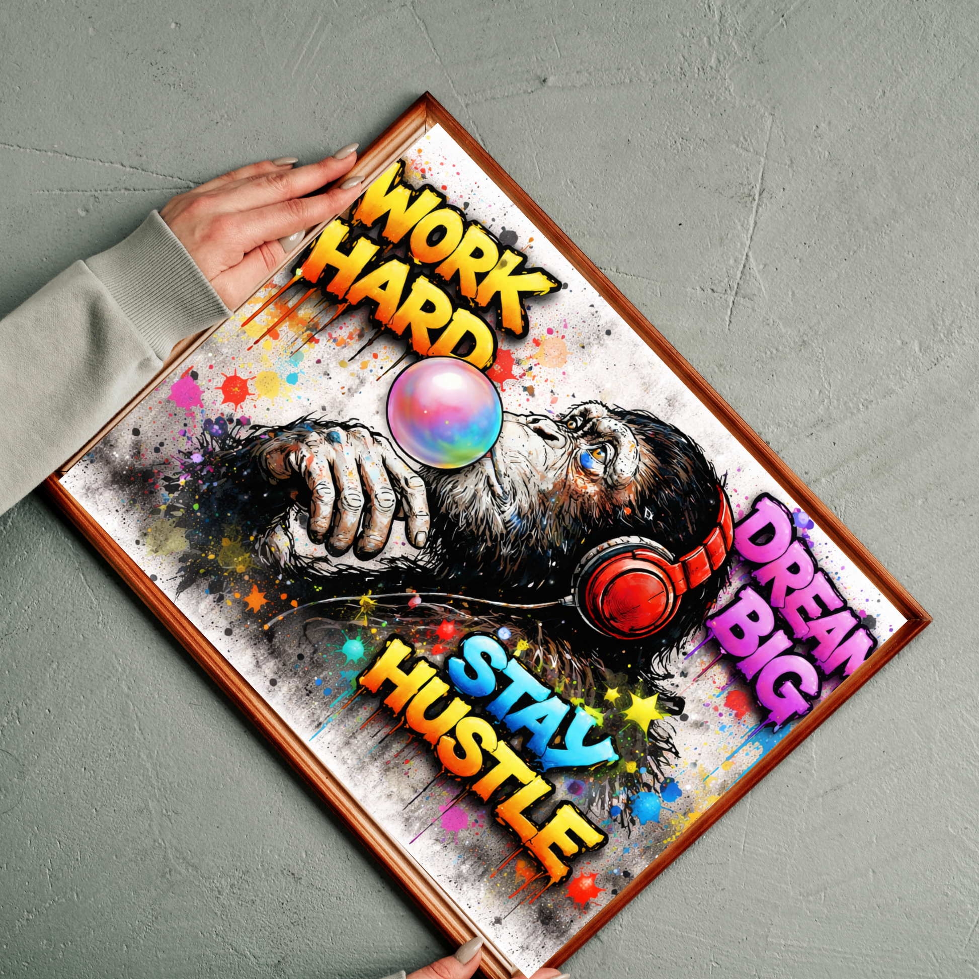 Motivational poster with colorful text and a person wearing headphones, held by a hand on a gray surface.